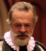 A photo of Leir’s face. He is not wearing his crown and is gazing downwards with a frown and furrowed brow.