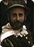 A photo of Alon Nashman as Mumford. Mumford has a dark beard and is wearing a hat.